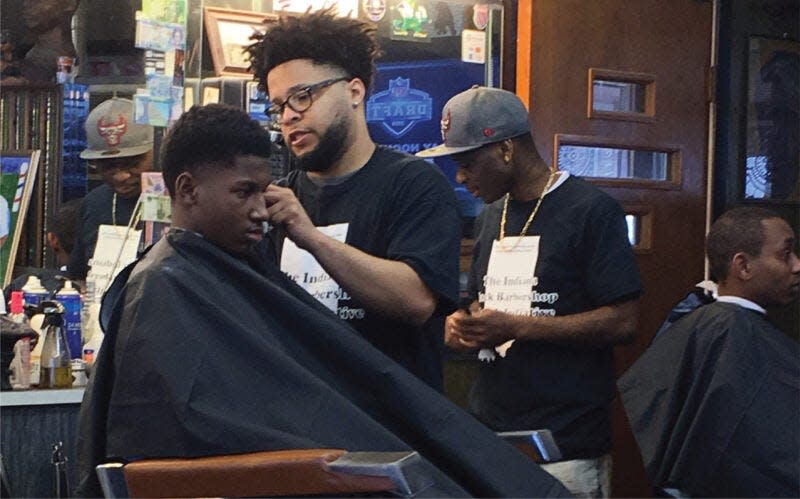 A young man receives a haircut at a past Indiana Black Barbershop Health Initiative event in South Bend.