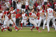 North Carolina State players celebrate after beating Arkansas 3-2 to advance to the College World Series during an NCAA college baseball super regional game Sunday, June 13, 2021, in Fayetteville, Ark. (AP Photo/Michael Woods)