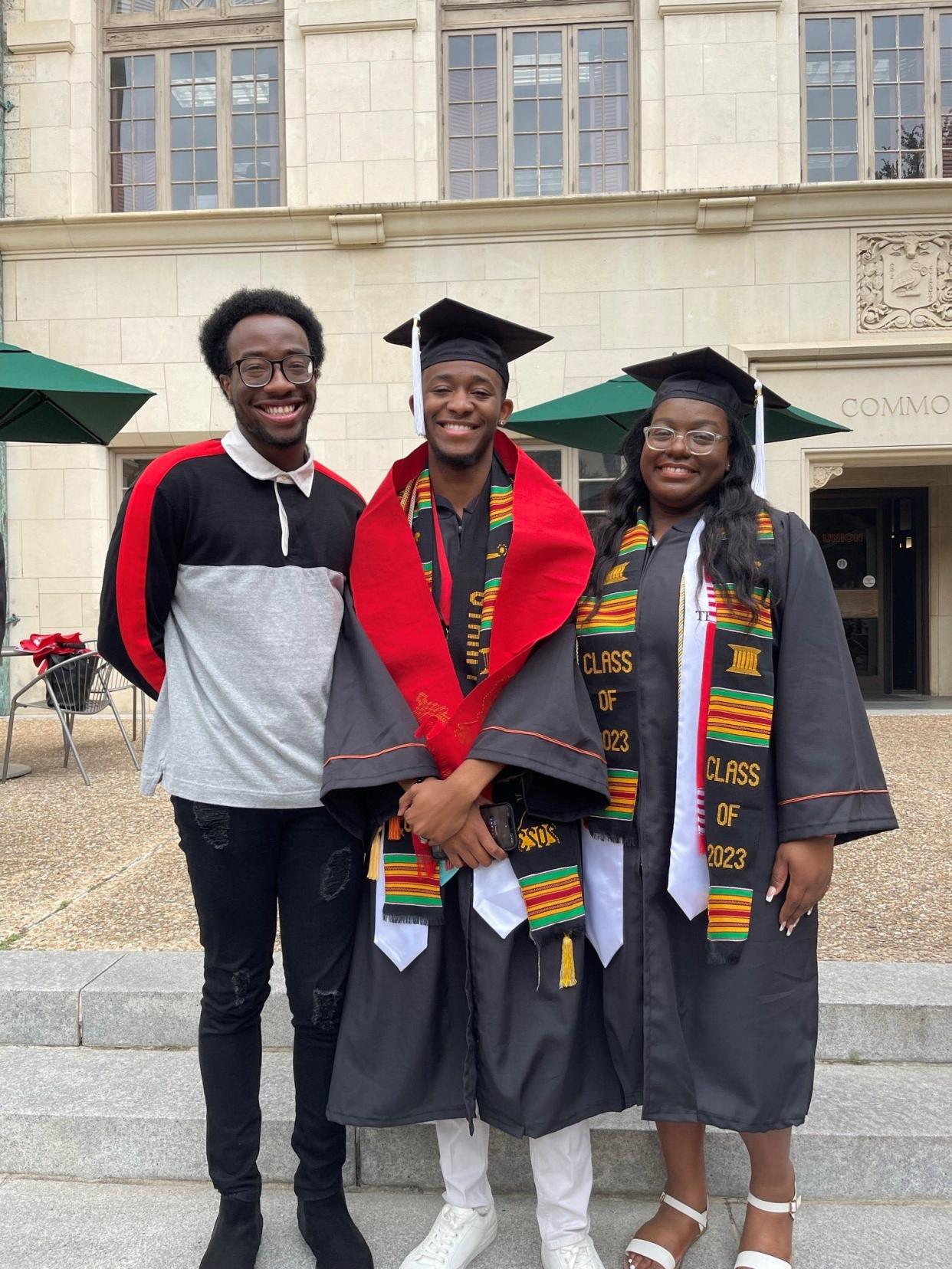 Zion James, center, stands with friend Justin Okougbodu, left, and fellow graduate Shelby Davis on the University of Texas campus after the Black Graduation ceremony in May 2023.
