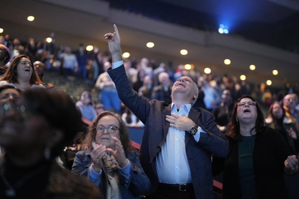 Churchgoers sing during a service at Lakewood Church Sunday, Feb. 18, 2024, in Houston. Pastor Joel Osteen welcomed worshippers back to Lakewood Church Sunday for the first time since a woman with an AR-style opened fire in between services at his Texas megachurch last Sunday. (AP Photo/David J. Phillip)