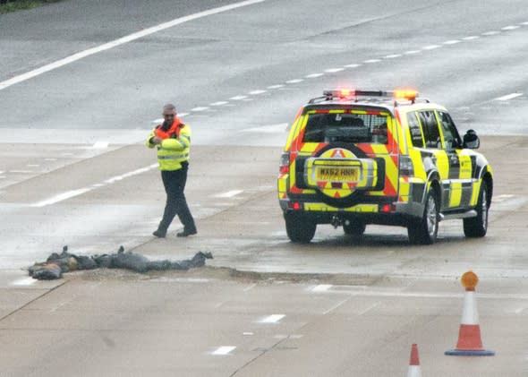 Mandatory Credit: Photo by Stephen Simpson/REX (4244281a) Traffic officer next to the pothole Three lanes of M25 closed after section of road collapses, Surrey, Britain - 14 Nov 2014 Three lane sof the M25 have been closed, causing masive traffic congestion and tailbacks, after a pothole appeared in the early hours of the morning. Surrey Police said many vehicles had been left with damaged tyres after the road surface near Leatherhead fell in during heavy rain at about 05:30 GMT. 