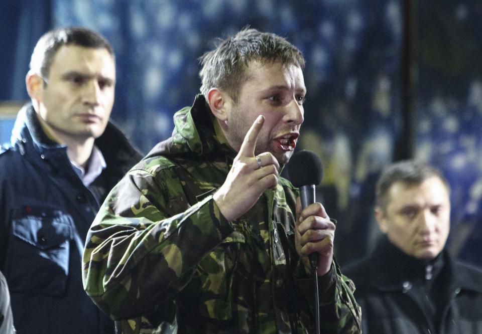 Anti-presidential protester Volodymyr Parasiuk addresses the crowd as opposition leader Vitaly Klitschko (L) looks on during a rally in Kiev February 21, 2014. When the history of the bloody turbulence in Ukraine is written, 26-year-old Parasiuk who learned combat skills in the army cadets may be recorded as the man who made up Viktor Yanukovich's mind to cut and run. To match Insight UKRAINE-CRISIS/HERO Picture taken February 21, 2014. REUTERS/Vitaliy Nosach (UKRAINE - Tags: POLITICS CIVIL UNREST PROFILE)