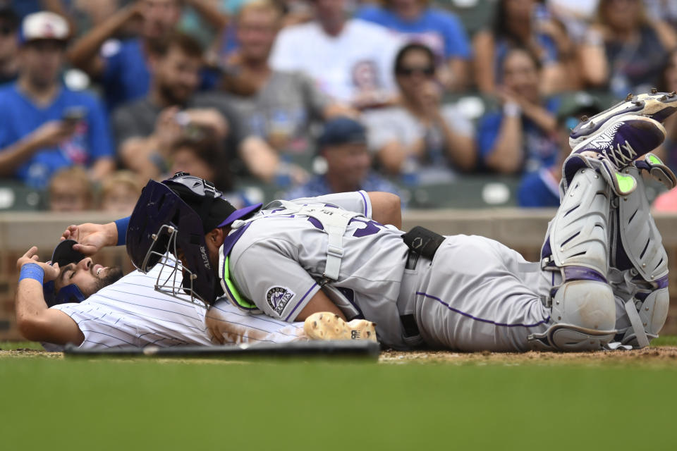 Chicago Cubs' Alfonso Rivas, left, is tagged out at home plate by Colorado Rockies catcher Elias Diaz during the fifth inning of a baseball game, Saturday, Sept. 17, 2022, in Chicago. (AP Photo/Paul Beaty)