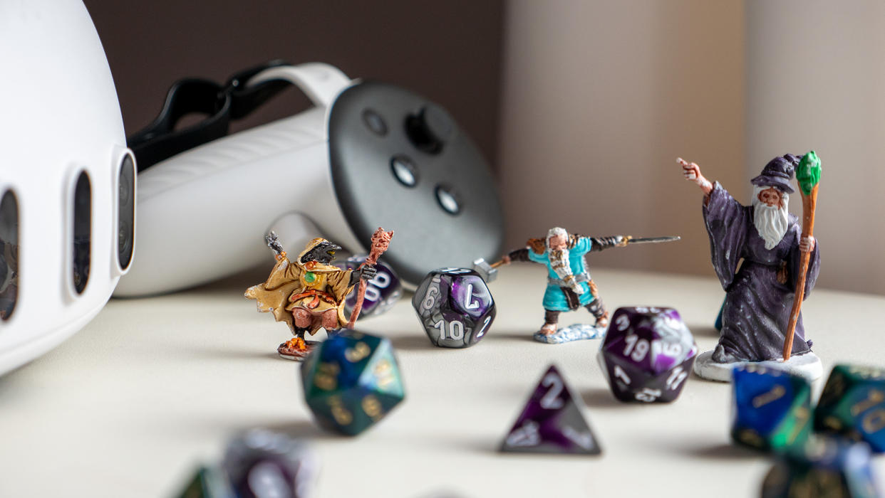  A Meta Quest 3 headset with controller alongside Dungeons and Dragons dice and characters. 