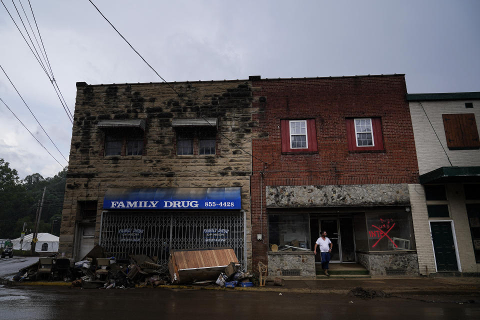 A person stands outside as storm clouds start to rain on Friday, Aug. 5, 2022, in Fleming-Neon, Ky. (AP Photo/Brynn Anderson)