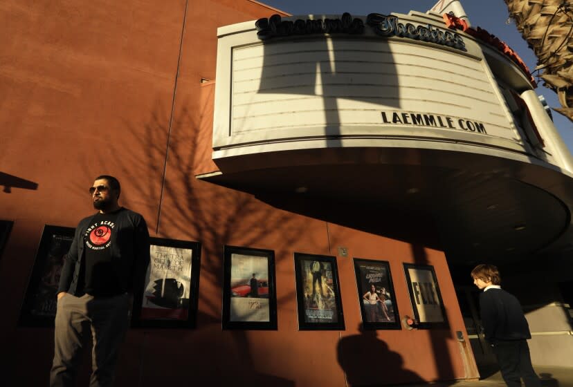 PASADENA, CA - FEBRUARY 2, 2022 - - Pedestrians walk past the Laemmle Theatre's Playhouse 7 featuring a blank marquee in Pasadena on February 2, 2022. The Laemmle Theatre's Playhouse 7, which opened February 5, 1999, was the first arthouse movie theater chain in Los Angeles. After 23 years in business it will close its doors this year. At present it is still open. (Genaro Molina / Los Angeles Times)