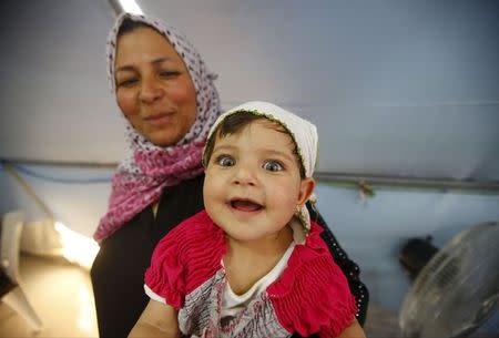 A Syrian refugee baby smiles in a tent at Suleymansah refugee camp in Akcakale in Sanliurfa province, Turkey, June 11, 2015. REUTERS/Osman Orsal