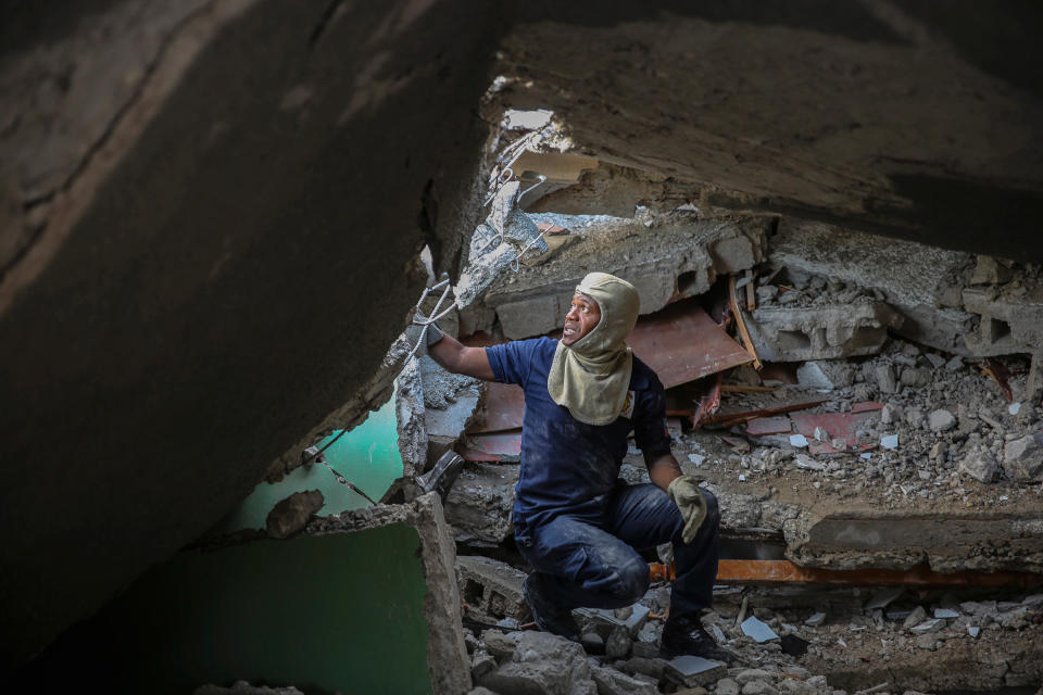 A firefighter searches for survivors inside a damaged building in Les Cayes on Aug. 15.<span class="copyright">Joseph Odelyn—AP</span>