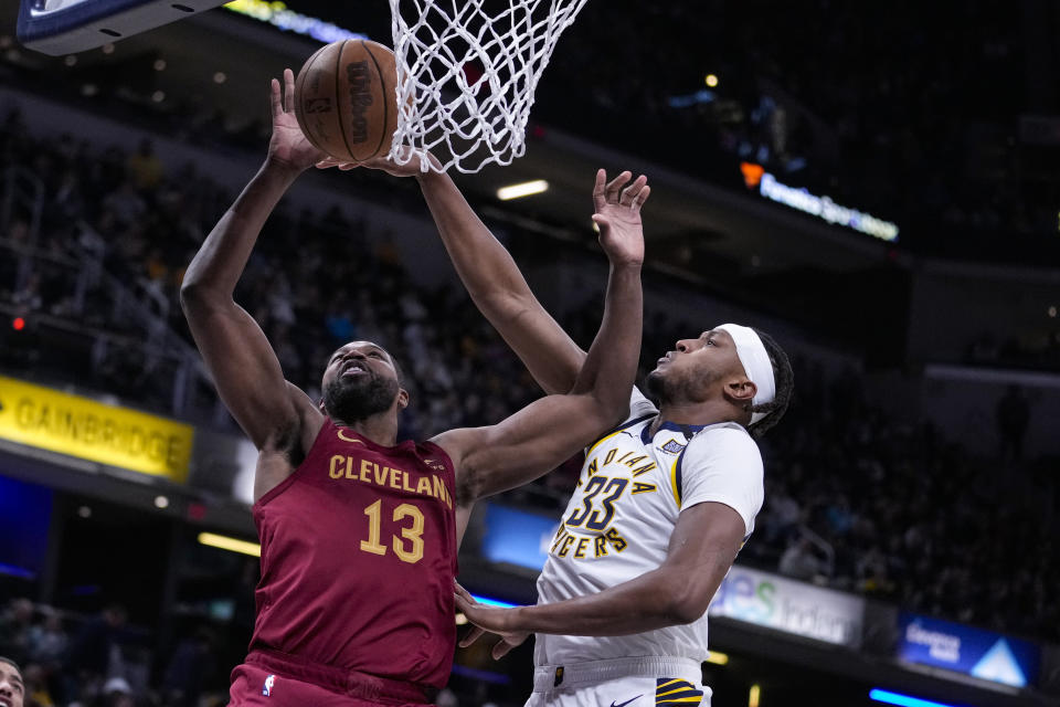 Cleveland Cavaliers center Tristan Thompson (13) shoots over Indiana Pacers center Myles Turner (33) during the first half of an NBA basketball game in Indianapolis, Monday, March 18, 2024. (AP Photo/Michael Conroy)