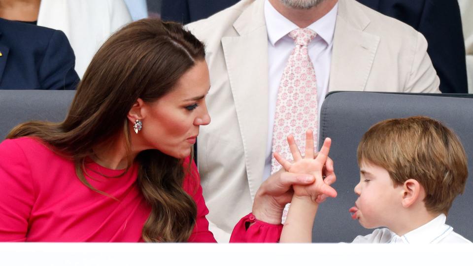 Prince Louis of Cambridge 'thumb's his nose' and sticks his tongue out at his mother Catherine, Duchess of Cambridge as they attend the Platinum Pageant on The Mall on June 5, 2022 in London, England.