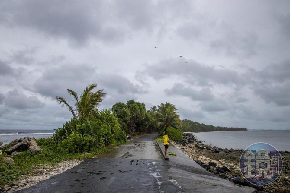 人站在最窄道路上，離海很近很近。