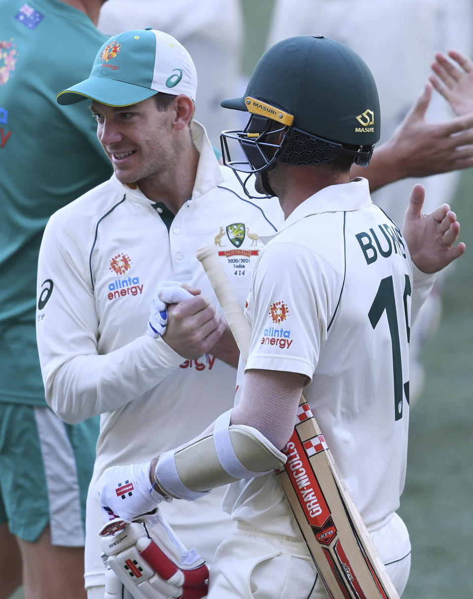 Australia's Joe Burns, right, is congratulated by his captain Tim Paine after Burns hit a 6 to win their match over India on the third day of their cricket test match at the Adelaide Oval in Adelaide, Australia, Saturday, Dec. 19, 2020. (AP Photo/David Mariuz)