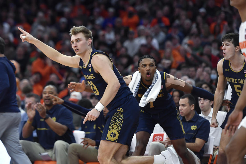 Notre Dame guard Dane Goodwin, left, reacts after scoring against Syracuse during the second half of an NCAA college basketball game in Syracuse, N.Y., Saturday, Jan. 14, 2023. (AP Photo/Adrian Kraus)