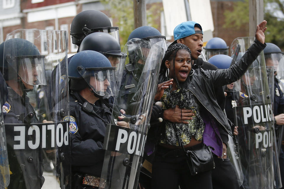 A Baltimore Police officers in riot gear push protestors back along Reisterstown Road near Mondawmin Mall, April 27, 2015 in Baltimore, Maryland. A group of young protestors clashed with police in the streets near Mondawmin Mall in the afternoon following Freddie Gray's funeral. (Photo by Drew Angerer/Getty Images)