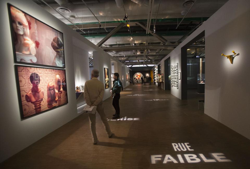 In this photo taken Tuesday, Oct. 29, 2013, visitors attend a press day for the exhibition 'Surrealism and the object', at Pompidou Center in Paris. The exhibition at Paris' Pompidou Center tells the previously untold story of how the Surrealists managed to reconcile their fantastical dreamings and Marxist politics by channeling their artistic message through everyday objects. The exhibition runs from 30 Oct. 30, 2013 until March 3, 2014. (AP Photo/Michel Euler)