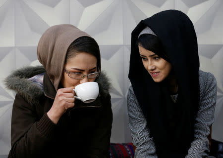 Sima Azimi (L), 20, a trainer and Sabera Bayanne, 20, a student at the Shaolin Wushu club, sit inside a restaurant in Kabul, Afghanistan February 2, 2017. REUTERS/Mohammad Ismail