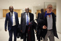 CAPTION CORRECTS SPELLING OF SURNAME Former president of the IAAF (International Association of Athletics Federations) Lamine Diack, center, arrives with his lawyer William Bourdon, right, at the Paris courthouse, Monday, Jan. 13, 2020. One of the biggest sports corruption cases to reach court is being heard in Paris from Monday, with explosive allegations of a massive doping cover-up at the top of track and field. (AP Photo/Thibault Camus)