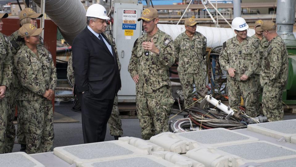 U.S. Navy Secretary Carlos Del Toro, left, speaks with Cmdr. Douglas Robb, commanding officer of the destroyer Spruance, during a visit to the ship in December 2022. (MC2 Stevin Atkins/U.S. Navy)