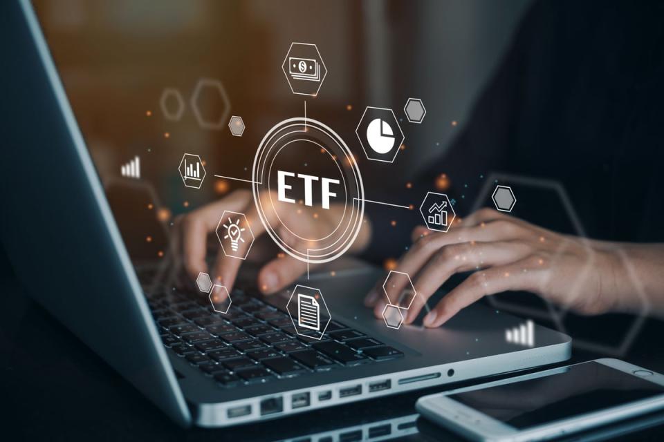 ETF bubble in front of hands typing on laptop.