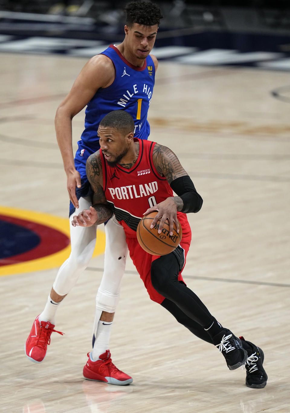 Portland Trail Blazers guard Damian Lillard (0) drives to the basket against Denver Nuggets forward Michael Porter Jr. (1) during the second half of Game 5 of a first-round NBA basketball playoff series Tuesday, June 1, 2021, in Denver. (AP Photo/Jack Dempsey)