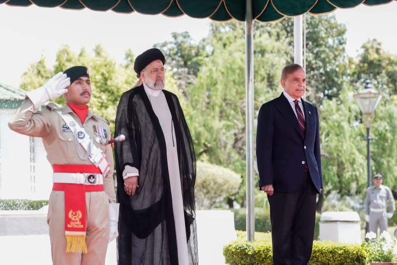 Prime Minister of Pakistan Shehbaz Sharif (R) receives Iranian President Ebrahim Raisi (C) ahead of their meeting. -/Iranian Presidency/dpa