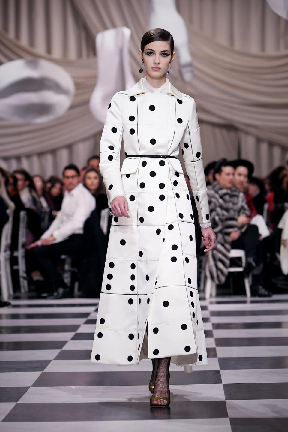 <p>A model wears a domino black and white themed trench coat from the Dior Haute Couture SS18 collection. (Photo: Getty) </p>