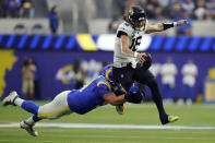 Jacksonville Jaguars quarterback Trevor Lawrence, right, is tackled by Los Angeles Rams defensive end Greg Gaines during the first half of an NFL football game Sunday, Dec. 5, 2021, in Inglewood, Calif. (AP Photo/Jae C. Hong)