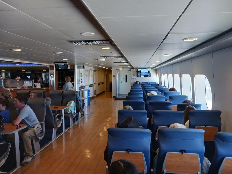 rows of Blue seats and shiny wood-like floors inside Lake Ferry