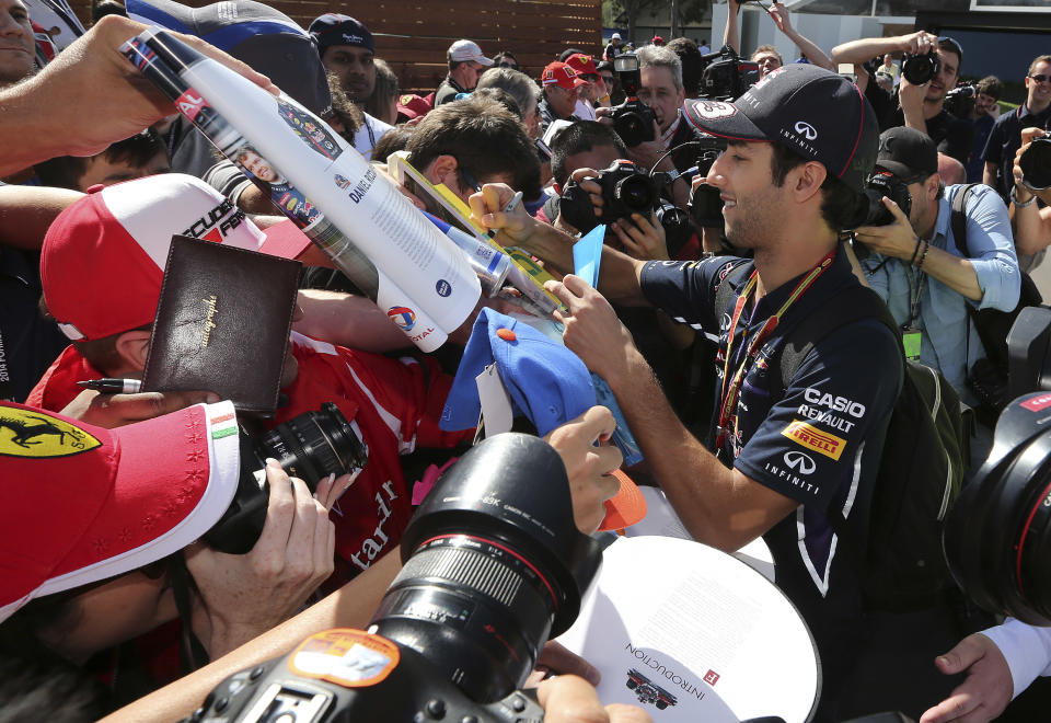 Red Bull driver Daniel Ricciardo of Australia signs autographs for fans ahead of the Australian Formula One Grand Prix at Albert Park in Melbourne, Australia, Thursday, March 13, 2014. (AP Photo/Rob Griffith)