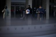 A woman wearing a face mask to help curb the spread of the coronavirus walks into the underpass under the street during sunset in Moscow, Russia, Wednesday, Dec. 2, 2020. Russia has registered a record number of coronavirus deaths for a second straight day. Currently, there is a country-wide mask mandate and mostly mild restrictions that vary from region to region. (AP Photo/Alexander Zemlianichenko)