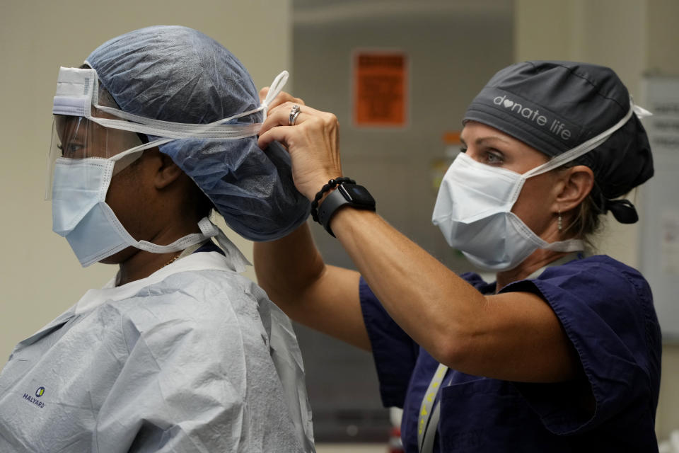 Meharry Medical College student Teresa Belledent, left, is helped with her operating room clothing by Deana Clapper, associate executive director of Tennessee Donor Services, before an organ recovery surgery June 15, 2023, in Jackson, Tenn. (AP Photo/Mark Humphrey)