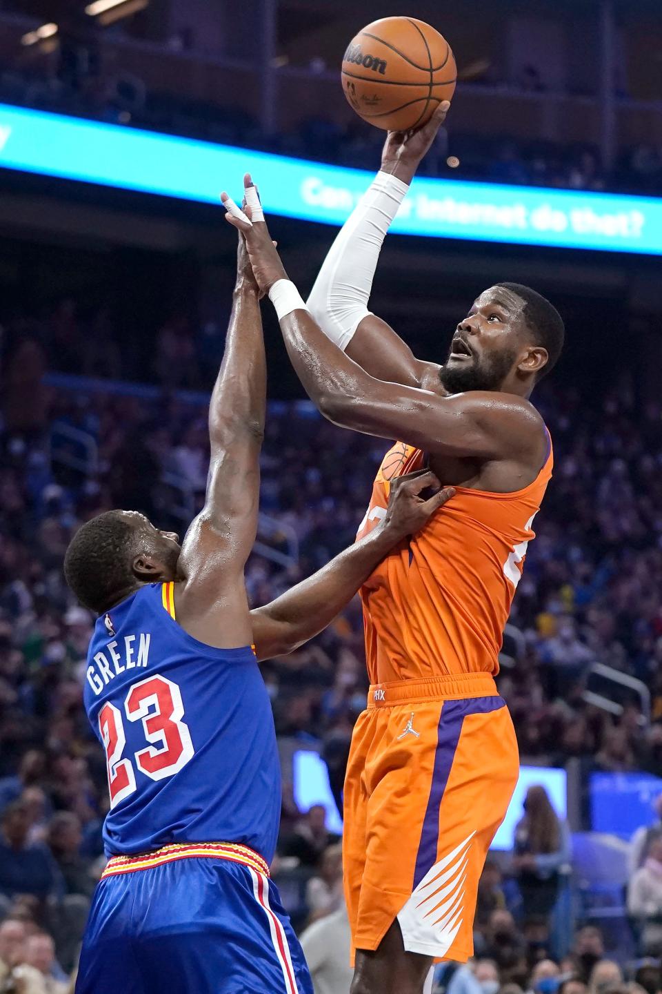 Phoenix Suns center Deandre Ayton, right, shoots against Golden State Warriors forward Draymond Green (23) during the first half of an NBA basketball game in San Francisco, Friday, Dec. 3, 2021. (AP Photo/Jeff Chiu)