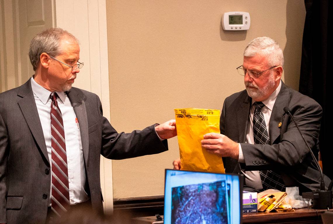 Creighton Waters, a prosecutor for the S.C. Attorney General’s office hands an evidence package to Jeff Croft, a SLED senior special agent, in the double murder trial of Alex Murdaugh at the Colleton County Courthouse in Walterboro, Monday, Jan. 30, 2023. Andrew J. Whitaker/The Post and Courier/Pool