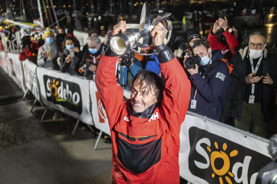 France's Yannick Bestaven lifts the trophy after winning the Vendee Globe solo around-the-world sailing race, in Les Sables-d'Olonne, western France, early Thursday, Jan.28, 2021. Frenchman Charlie Dalin crossed the line first Wednesday but Bestaven was getting 10 hours, 15 minutes for helping in the search and rescue of another competitor off Cape Horn last November. (AP Photo/Yohan Bonnet)