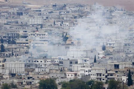 Smoke rises from the Syrian town of Kobani, seen from near the Mursitpinar border crossing on the Turkish-Syrian border in the southeastern town of Suruc in Sanliurfa province, October 16, 2014. REUTERS/Kai Pfaffenbach