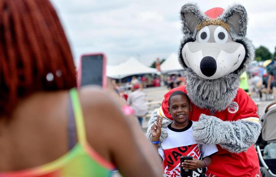 Eight-year-old Jacob Watson of St. Louis poses with KC Wolf as his mother Letica Watson takes a photo. The three-day Kansas City BBQ Festival in the parking lot of the GEHA Field at Arrowhead Stadium concluded Sunday, July 11, 2021.