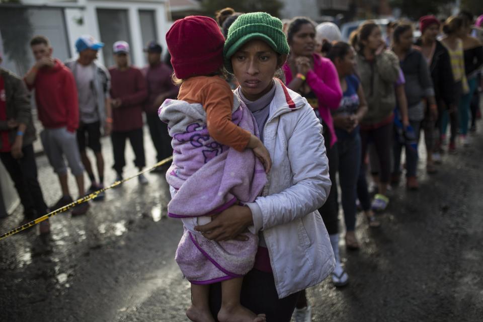 FILE - Maria del Carmen Mejia holds her daughter Britany Sofia while standing a line outside a migrant shelter in Tijuana, Mexico, Nov. 22, 2018. (AP Photo/Rodrigo Abd, File)
