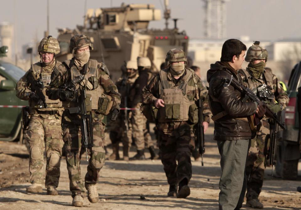 Afghan security forces and U.S. soldiers arrive at the site where a suicide attacker rammed a car bomb into a NATO convoy killing two foreign civilian contractors, in the Afghan capital Kabul, Afghanistan, Monday, Feb. 10, 2014. The Islamic militant group Hizb-i-Islami claimed responsibility for the attack in eastern Kabul, saying it would drive all foreign forces from Afghanistan. (AP Photo/Rahmat Gul)