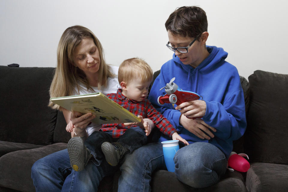 In this Friday, Nov. 16, 2018, photo, Anna Ford, left, and her partner, Sara Watson, play with their son Eli at home in the village of Saunderstown, in Narragansett, R.I. Three years after the landmark U.S. Supreme Court case that gave same-sex couples the right to marry nationwide, a patchwork of outdated state laws governing who can be a legal parent presents obstacles for many LGBTQ couples who start a family, lawyers say. (AP Photo/Michael Dwyer)