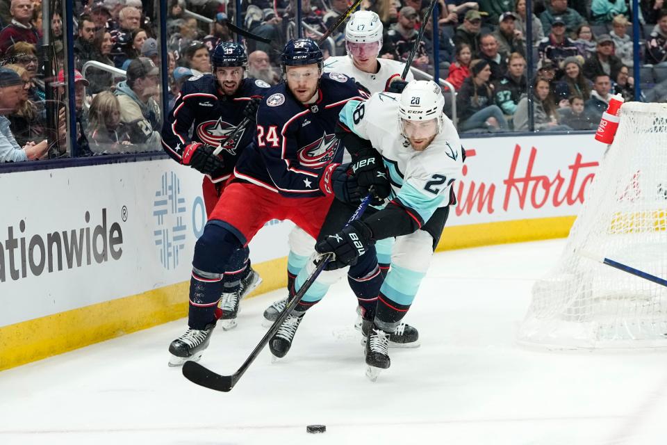 Mar 3, 2023; Columbus, Ohio, USA;  Columbus Blue Jackets right wing Mathieu Olivier (24) fights for the puck with Seattle Kraken defenseman Carson Soucy (28) during the first period of the NHL hockey game at Nationwide Arena. Mandatory Credit: Adam Cairns-The Columbus Dispatch