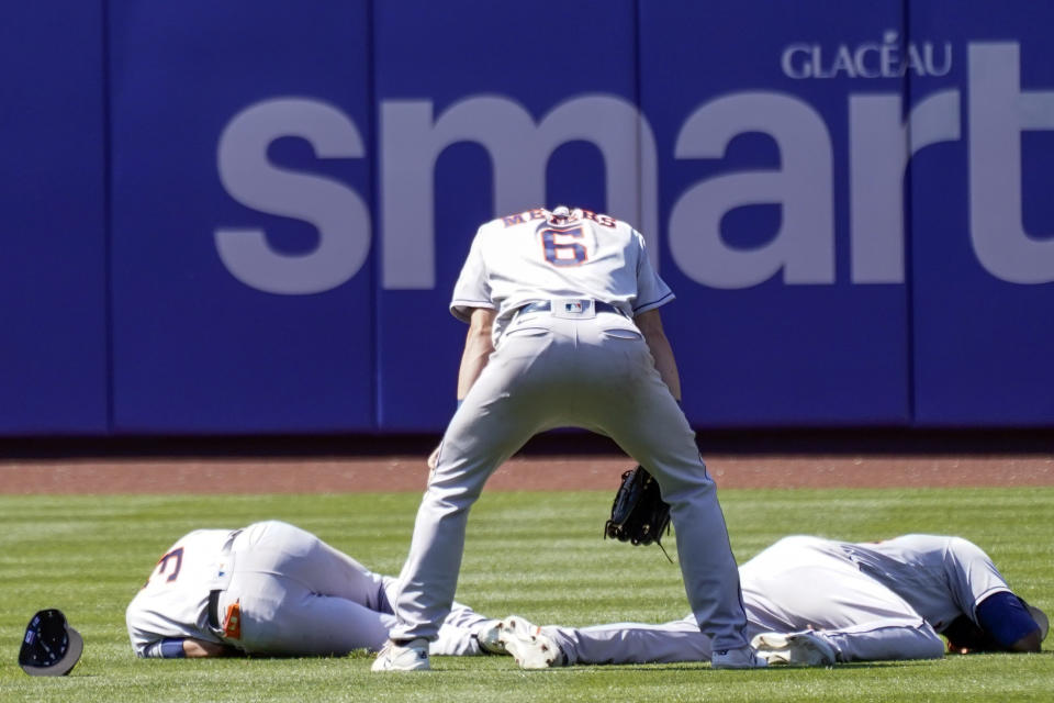 Houston Astros' Jake Meyers (6) watches as Jeremy Pena, left, and Yordan Alvarez fall to the ground after colliding catching a fly ball by New York Mets' Dominic Smith during the eighth inning of a baseball game, Wednesday, June 29, 2022, in New York. (AP Photo/Mary Altaffer)