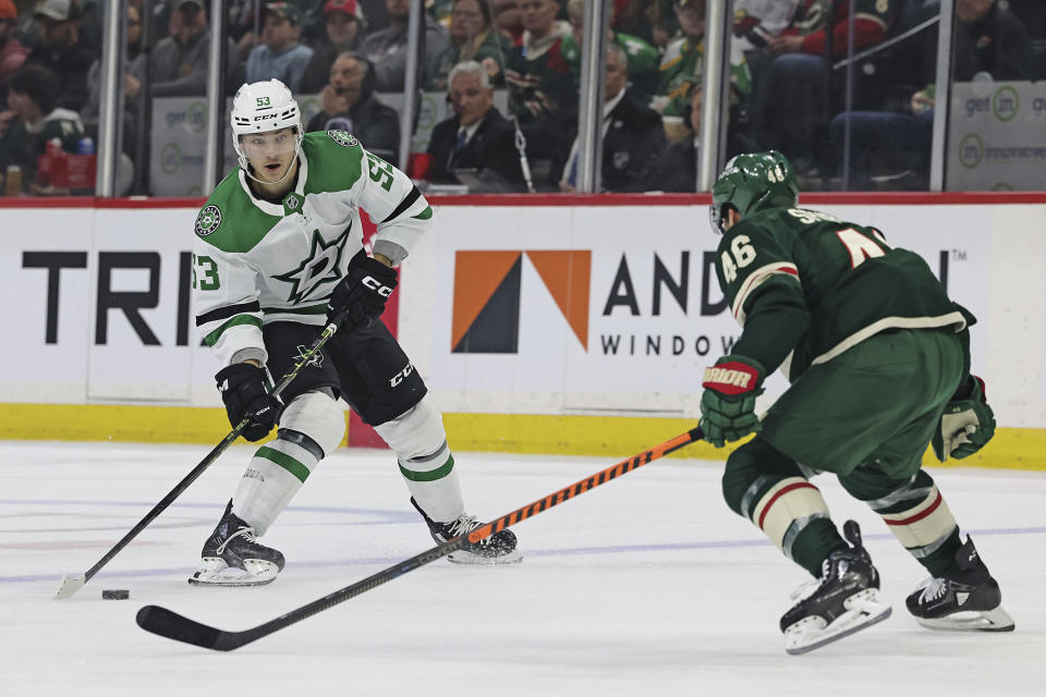 Dallas Stars center Wyatt Johnston (53) handles the puck in front of Minnesota Wild defenseman Jared Spurgeon (46) during the second period of Game 3 of an NHL hockey Stanley Cup first-round playoff series Friday, April 21, 2023, in St. Paul, Minn. (AP Photo/Stacy Bengs)