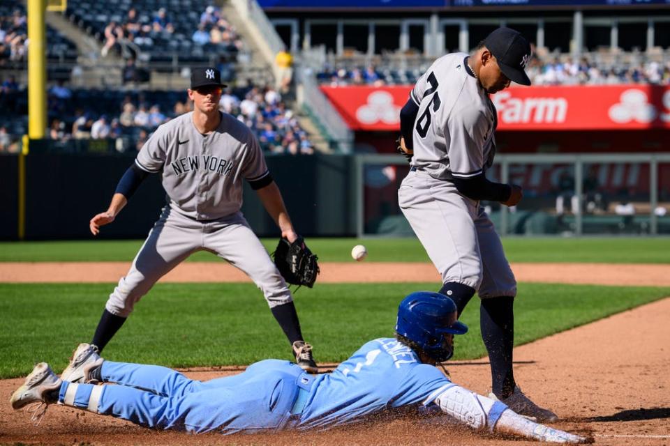 Kansas City Royals' MJ Melendez slides safely into first base as New York Yankees first baseman DJ LeMahieu, left and New York Yankees relief pitcher Jhony Brito can't connect for the out during the fifth inning of a baseball game, Sunday, Oct. 1, 2023, in Kansas City, Mo. (AP Photo/Reed Hoffmann)