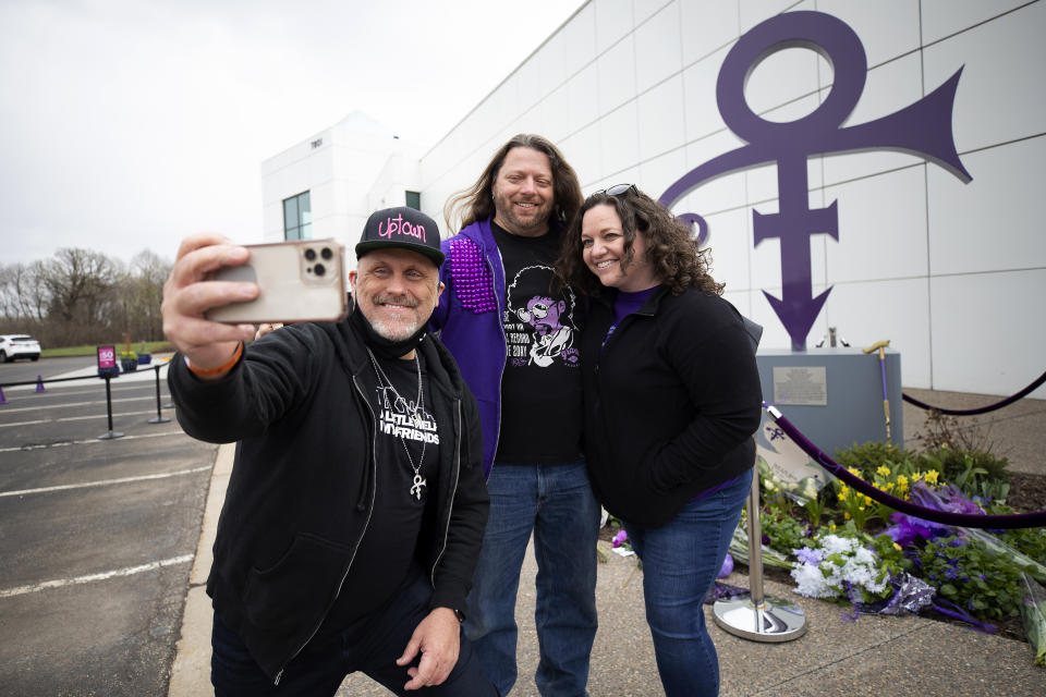 Prince fans were invited to Paisley Park, 20 at a time, to pay respect to the legendary musician and artist during the 5th anniversary of his death, Wednesday, April 21, 2021, in Chanhassen Minn. Fans took photos in front of the iconic Prince symbol statue outside of the museum before entering. (AP Photo/Stacy Bengs)