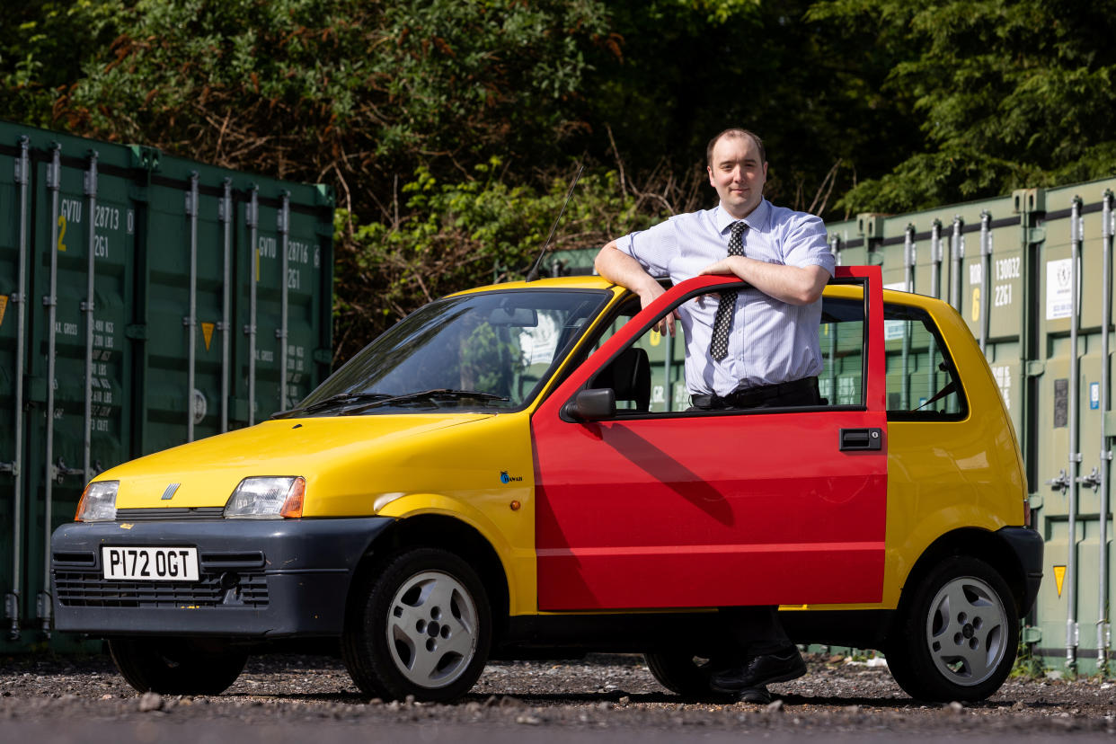 Auctioneer Andy Stowe with the famous yellow Fiat Cinquecento from the Inbetweeners TV show which is coming up for auction at East Bristol Auctions. (SWNS)