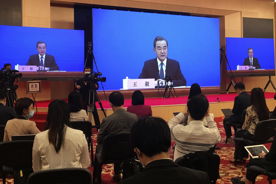 FILE - In this Sunday, May 24, 2020, file photo, China's Foreign Minister Wang Yi is seen broadcasted remotely on big screens at the media center during a press conference held on the sideline of the National People's Congress in Beijing. Wang is dismissing claims that the country is exploiting the coronavirus outbreak to expand its footprint in the South China Sea, labeling such accusations as “sheer nonsense." (AP Photo/Ken Moritsugu, File)