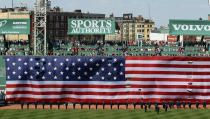 BOSTON, MA - APRIL 20: A giant flag covers the Green Monster as the national anthem is played before the game between the New York Yankees and the Boston Red Sox on April 20, 2012 at Fenway Park in Boston, Massachusetts. Today marks the 100 year anniversary of the ball park's opening. (Photo by Elsa/Getty Images)