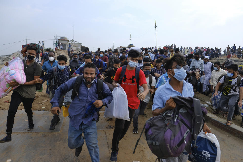 Thousands of people leaving for their native places to celebrate Eid-al-Fitr rush to the Mawa ferry terminal ignoring risks of coronavirus infection in Munshiganj, Bangladesh, Thursday, May 13, 2021. (AP Photo/Mahmud Hossain Opu)