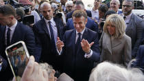 French President Emmanuel Macron and his wife Brigitte Macron greet the crowd as they arrive at Jackson Square in New Orleans, Friday, Dec. 2, 2022. (AP Photo/Gerald Herbert)