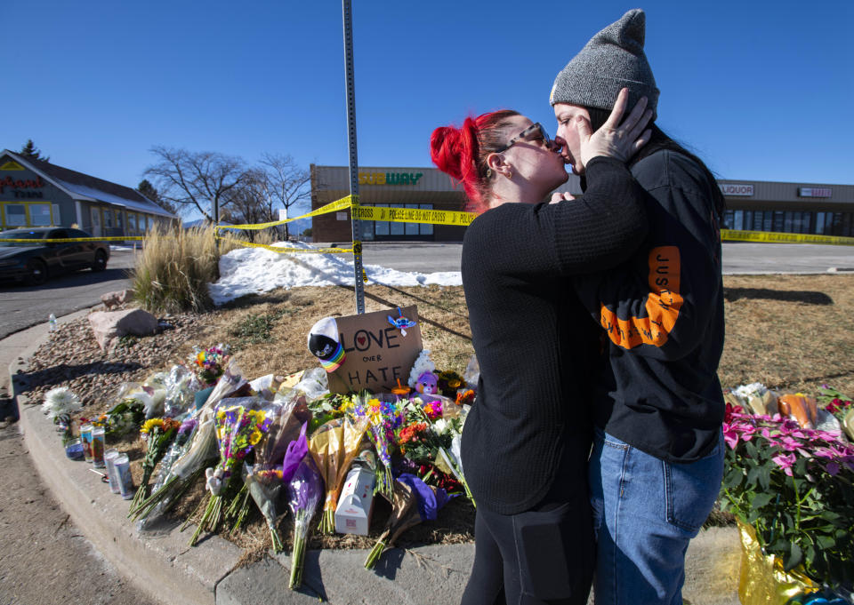 Sophie Kamerrer, left, and Torrey Lovett embrace while visiting a makeshift memorial near Club Q Sunday, Nov. 20, 2022, after a shooting Saturday night at the Colorado Springs, Colo., bar. (Christian Murdock/The Gazette via AP)